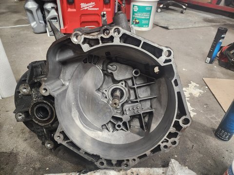 Removed transmission with its open bellhousing and central input shaft visible.